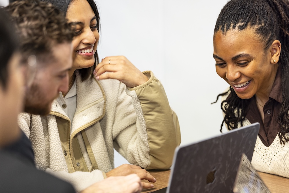 students in a group looking at a laptop