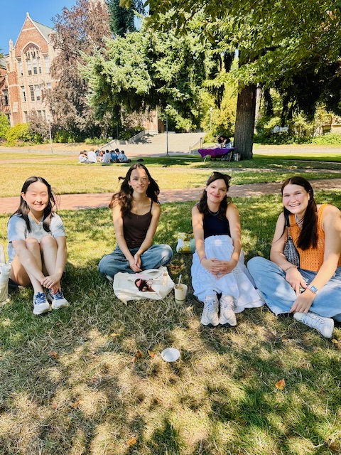 Students sitting in a small group together on the quad in the sunshine.