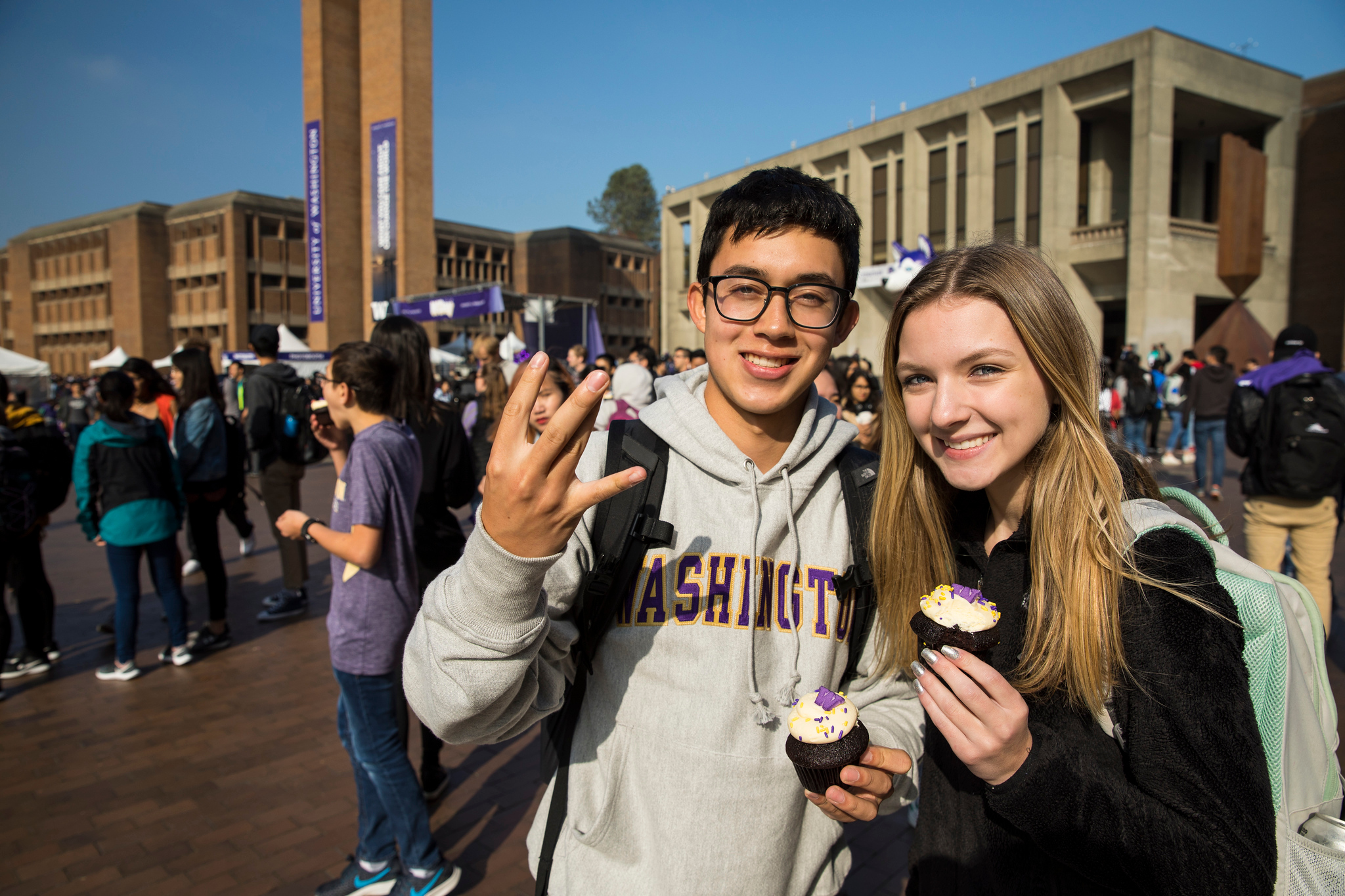Students on campus holding cupcakes